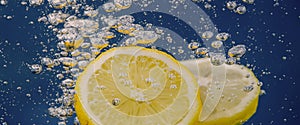 Underwater lemon slice in soda water or lemonade with bubbles