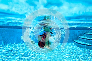 Underwater little boy with mask in swimming pool