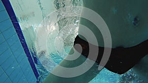 Underwater - man dives in swimming pool