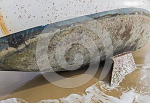 The underwater part of the boat overgrown clams