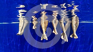 Underwater photo of bare feet in swimming pool