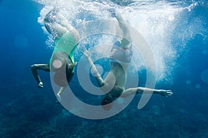 underwater photo of couple diving together
