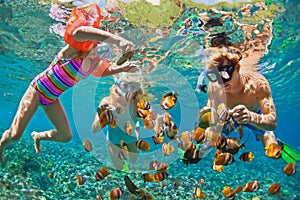 Underwater photo. Happy family snorkelling in tropical sea photo