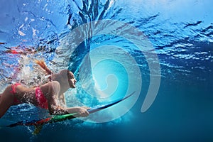 Underwater photo of surfer girl diving under ocean wave