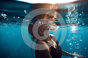 Underwater photo with woman in ocean and bubbles