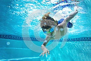 Underwater photo of a Young Boy swimmer in the Swimming Pool with Goggles.