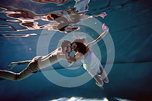 Underwater in the pool with the purest water. Loving couple hugging. The feeling of love and closeness