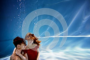 Underwater in the pool with the purest water. Loving couple hugging. The feeling of love and closeness. Soft focus