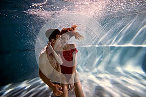 Underwater in the pool with the purest water. Loving couple hugging. The feeling of love and closeness. Soft focus