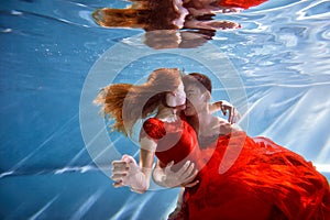 Underwater in the pool with the purest water. Loving couple hugging. The feeling of love and closeness. Soft focus