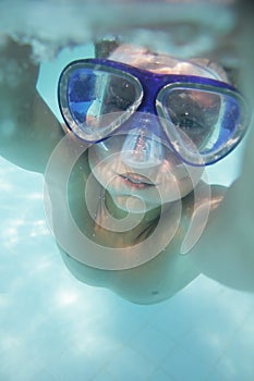 Underwater portrait of child diving in mask