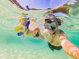 Underwater portrait of father and son snorkeling together