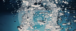 Underwater pouring ice cubes falling into clear watering background