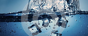 Underwater pouring ice cubes falling into clear watering background