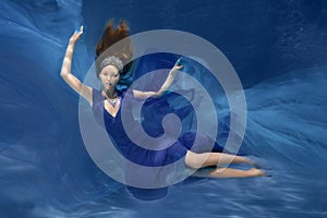 Underwater Queen. Girl mermaid. Underwater scene. A woman, a fashion model in the water in a beautiful dress swims like a fish