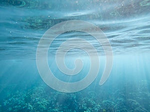 Underwater rays of light with ripples on surface