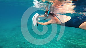 Underwater scooter. Woman swims using modern innovative diving gadget.