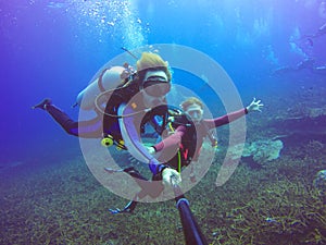 Underwater scuba diving selfie shot with selfie stick. Deep blue sea.