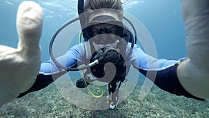 Underwater selfie photo of a male suba diver in the blue ocean.