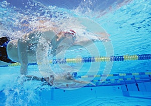 Underwater shot of three male athletes in swimming competition