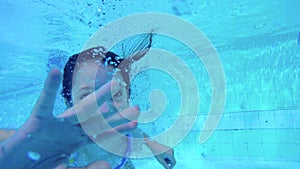 Underwater shot of two kids diving in a swimming pool