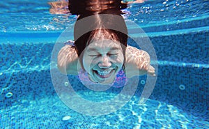 Underwater shot of young woman diving into the swimming pool