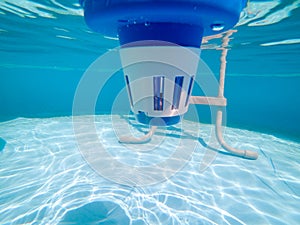 Underwater view of a chlorine dispenser in a swimming pool