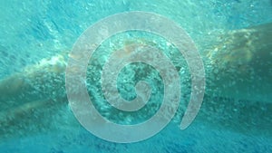 Underwater view of girl jumping in the pool, slow motion