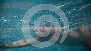 Underwater view of professional swimmer training in swimming pool, 4k 120 fps super slow motion raw video. Triathlete