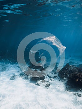 Underwater view in transparent ocean with plastic bag and rubbish, ecological problem