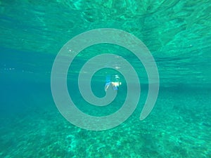 Underwater view of a woman snorkeling in the tropical sea