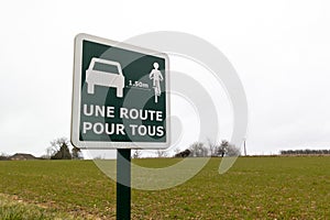 Une route pour tous french text means road sharing cars and bikes on road panel square green photo