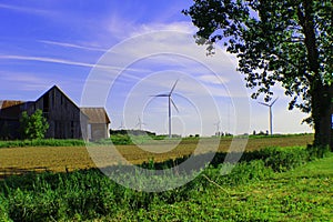 Une vieille grange et des ÃÂ©oliennes dans un ciel bleu photo