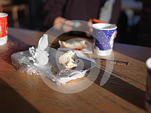 Uneaten bun and disposable tea glasses on a table