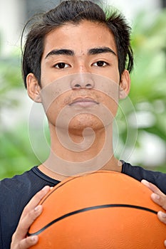 Unemotional Asian Person With Basketball