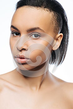 Unemotional Negroid young woman standing in the studio