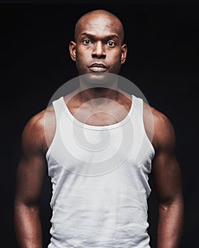 Unemotional young black man in tank top