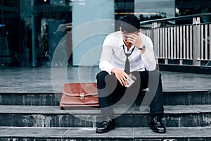 Unemployed Tired or stressed businessman sitting on the walkway