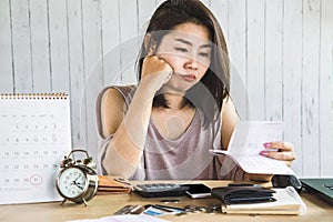 Unemployment Asian woman looking at saving account book no money for expenses payment