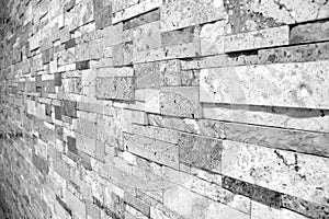 Uneven masonry marble Brick wall in black and white selective focus taken from a side