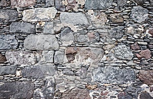 Uneven real stone wall background or texture