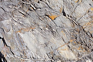 Uneven stone texture background with yellow lichen