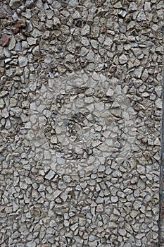 Uneven surface of wall with light gray gravel pebble dash