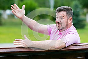 An unexpected emotional meeting in the park. A man with a beard waves his hand to his acquaintances