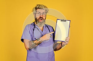 unexpected news. mature bearded male doctor with a folder in uniform standing. Portrait of serious nurse with a folder