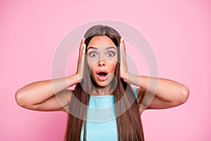 Unexpected Portrait of astonished confused teen model on rose-colored background listen information wonder touching head