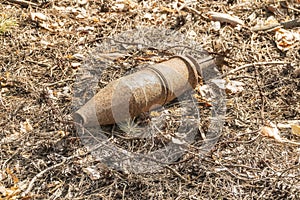 Unexploded rusty projectile in the forest