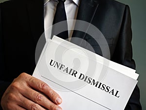 Unfair dismissal concept. Man is holding stack of papers