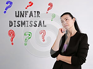 UNFAIR DISMISSAL question marks inscription on the gray wall