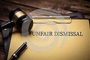 Unfair dismissal text on Document and gavel isolated on wooden office desk